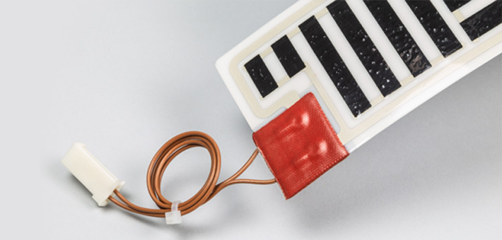 Polyester heating element terminated in a corner of the short side, with silicone patch